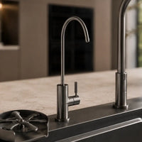 Stainless steel kitchen faucet on a modern kitchen sink with blurred background
