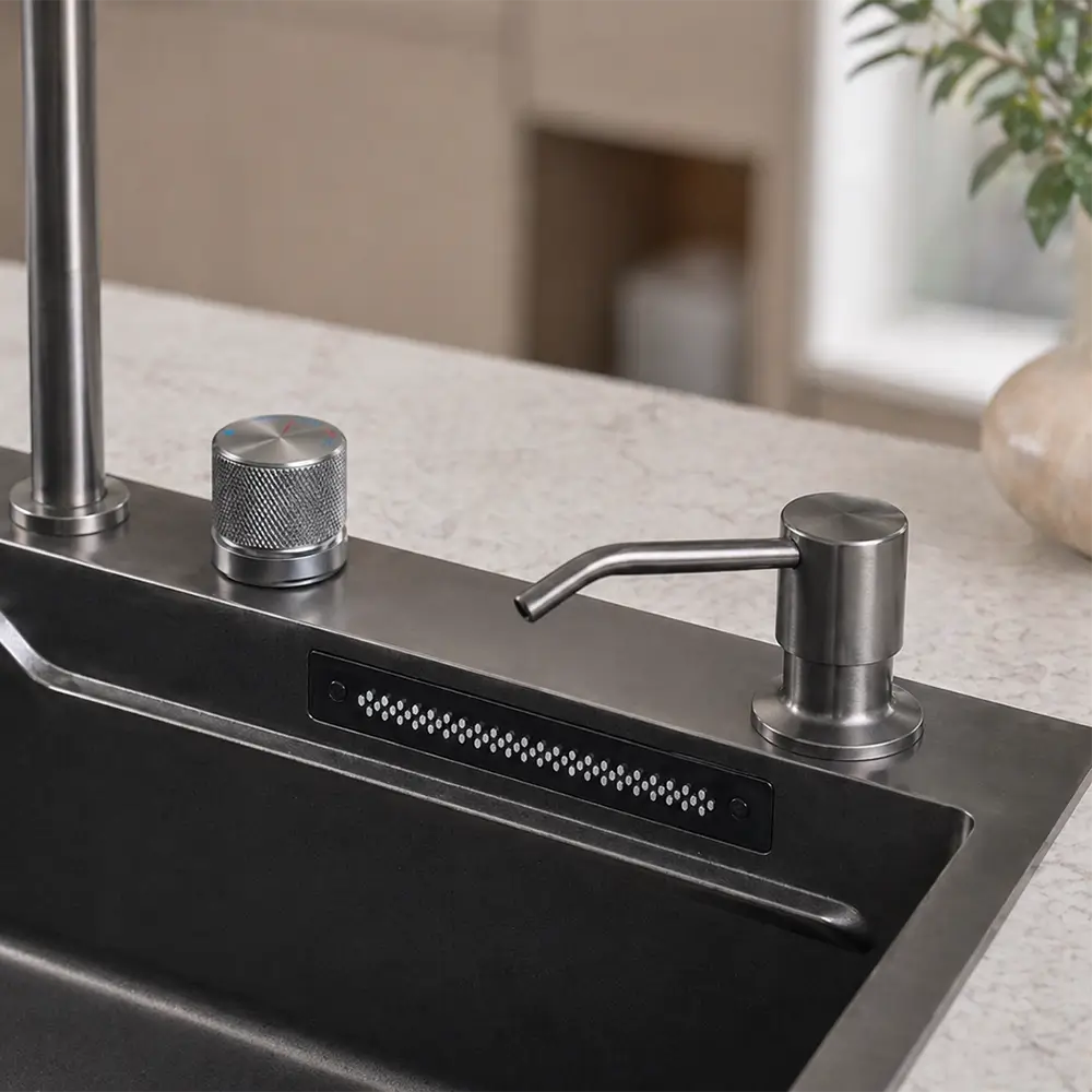 Stainless steel integrated soap dispenser on a kitchen sink with a blurred background